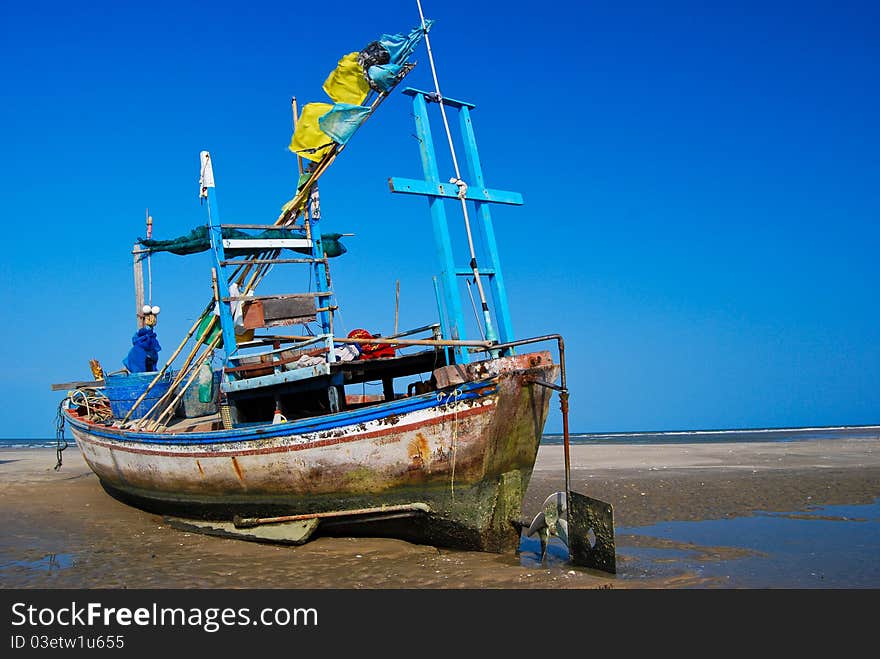 Fisherman boat on the sea shore , with bright blue sky background