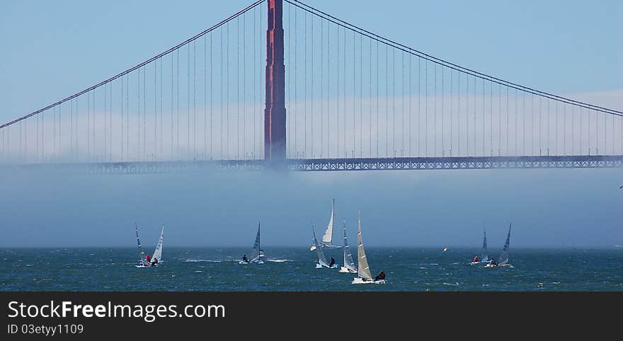 Windsurfers enjoy an afternoon under the bridge as the fog dissipates. Windsurfers enjoy an afternoon under the bridge as the fog dissipates.