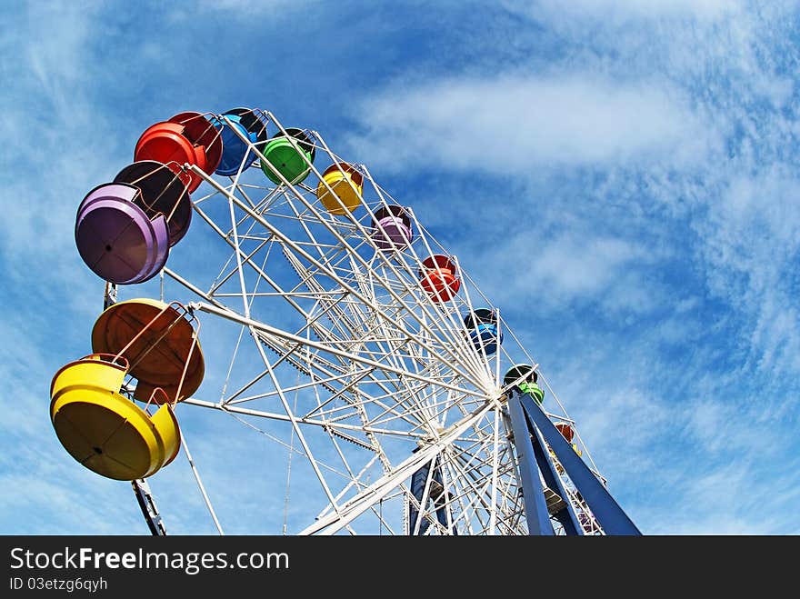 Brightly colored Ferris wheel against the blue sky