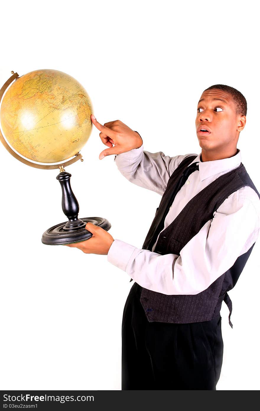 A young man pointing at a globe and looking surprised. A young man pointing at a globe and looking surprised