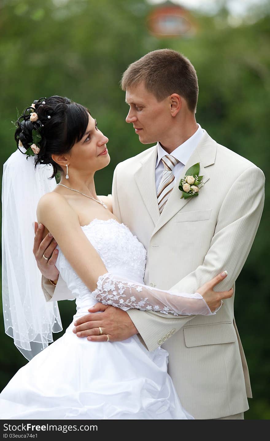 Bride and groom embracing in the park