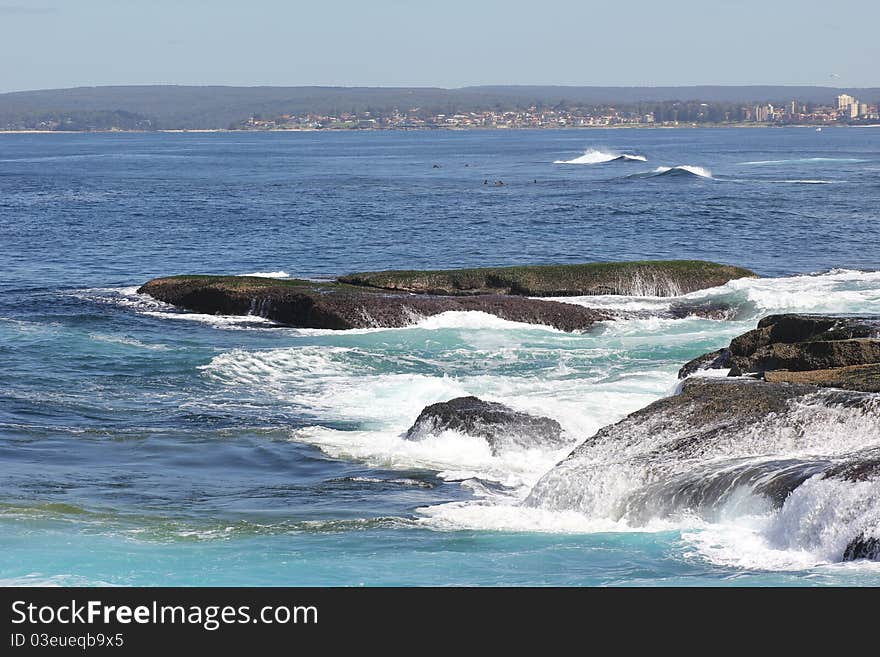 Blue ocean waters with waves washing over the rocks - at the seaside town Cronulla (Australia). Blue ocean waters with waves washing over the rocks - at the seaside town Cronulla (Australia)