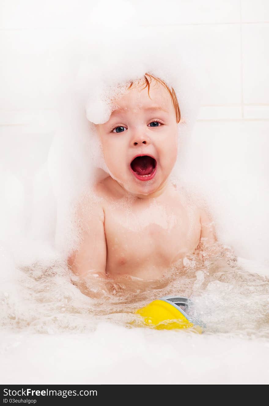 Cute one year old boy taking a relaxing bath with foam. Cute one year old boy taking a relaxing bath with foam