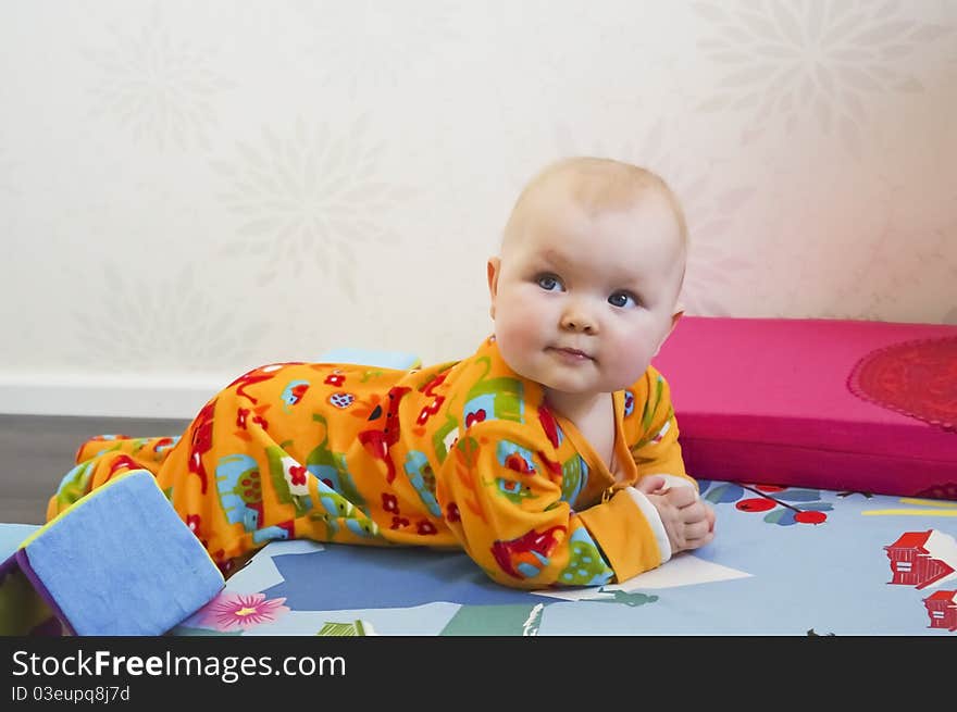 Cute 8 months old baby lying on bed in casual home enviroment