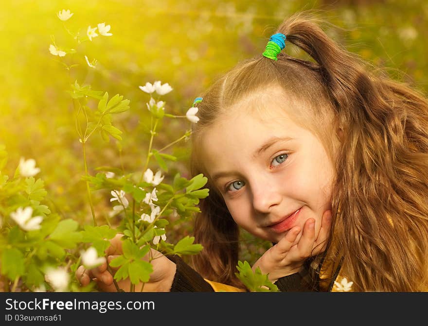 Little girl portrait at spring forest flowers