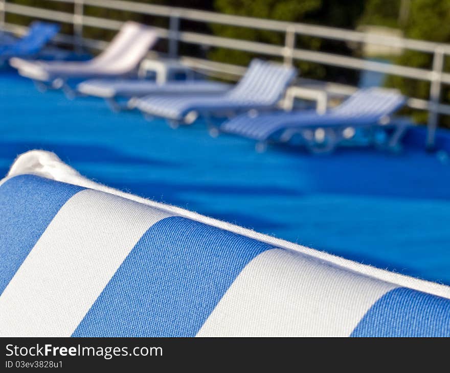 Row of lounge chairs, with blue and white stripes.