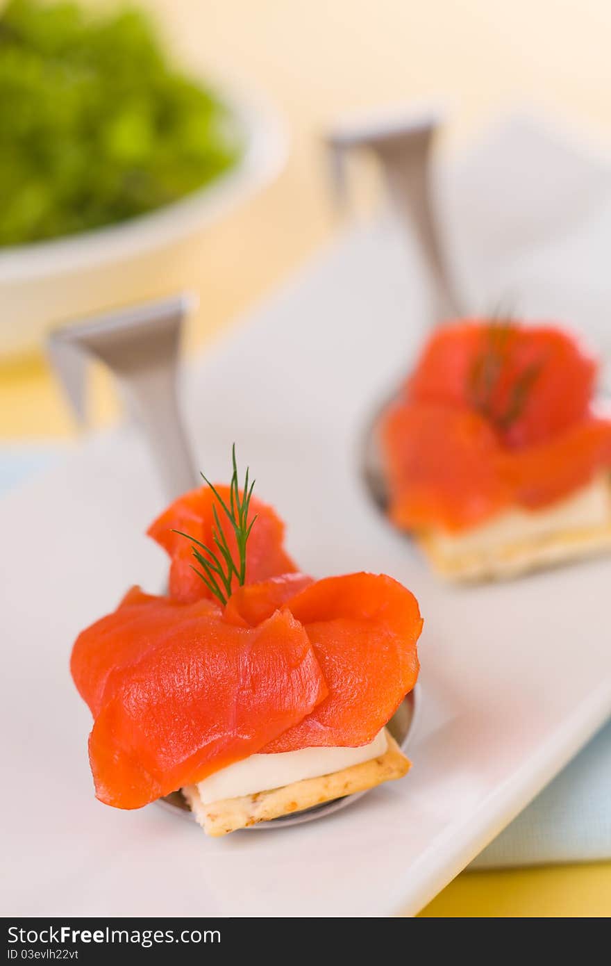 Appetizer smoked salmon with cream cheese and salad in the background. Very shallow depth of field. Appetizer smoked salmon with cream cheese and salad in the background. Very shallow depth of field.