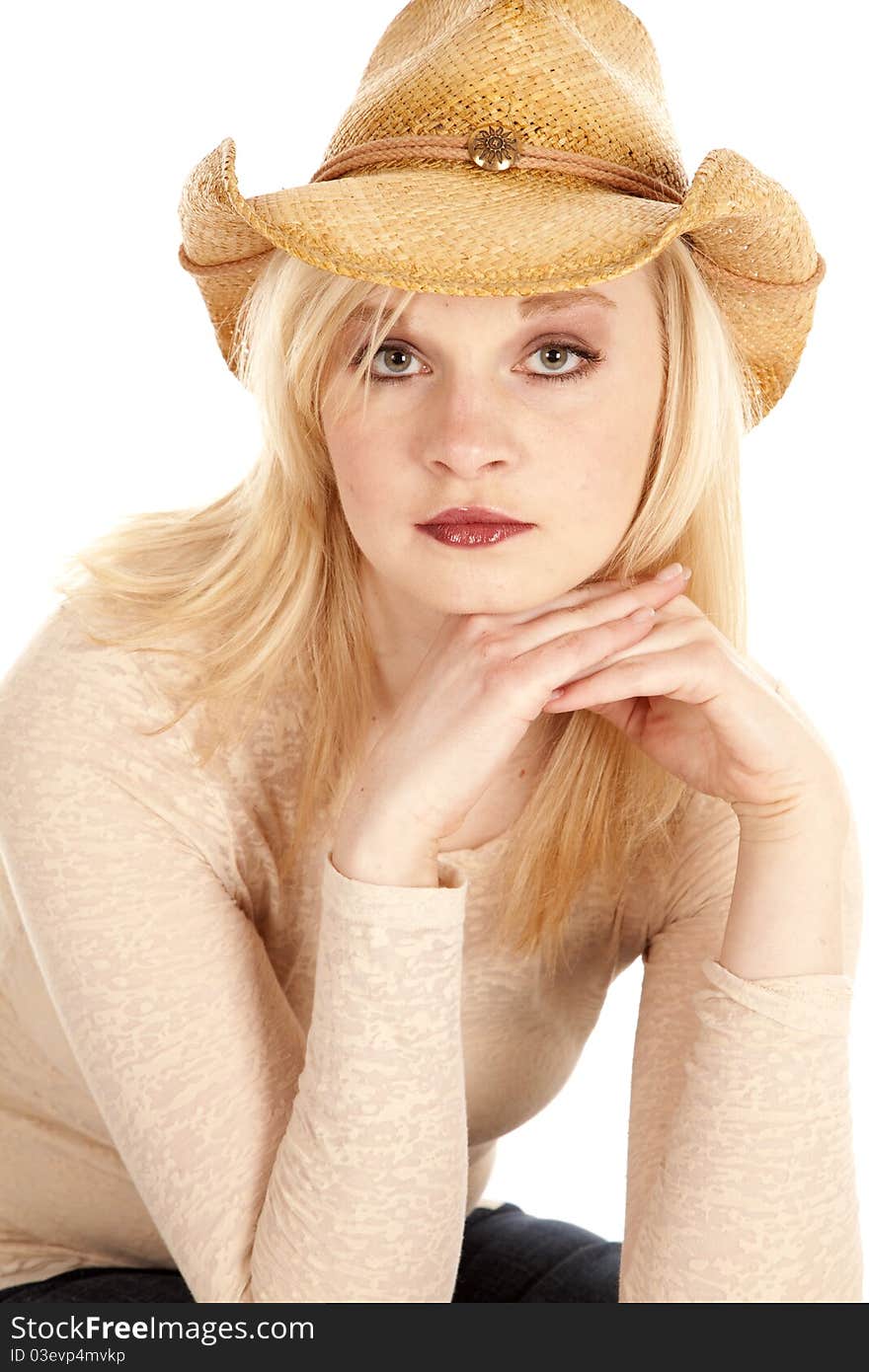 A close up of a cowgirls face with her hands by her chin. A close up of a cowgirls face with her hands by her chin.