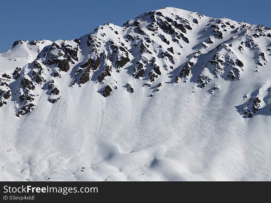 Snowboarders and skiers tracks on the mountain after heli-skiing. Snowboarders and skiers tracks on the mountain after heli-skiing