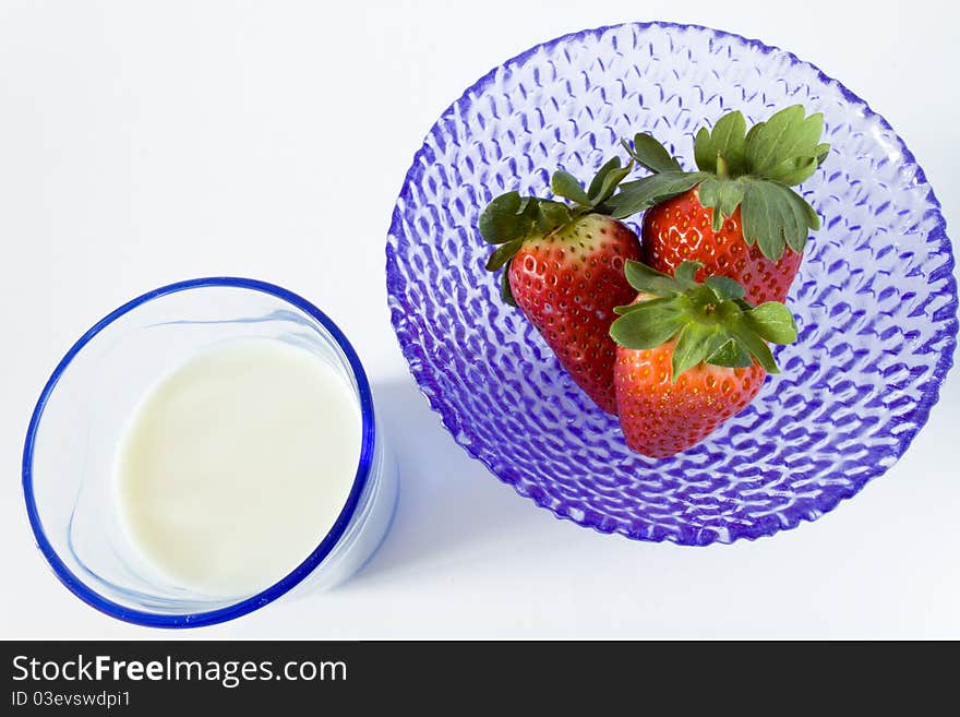 Blue cup of strawberries and glass of milk, view of above. Blue cup of strawberries and glass of milk, view of above