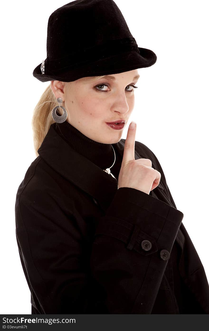 A beautiful girl in her black hat and over coat with a secret .