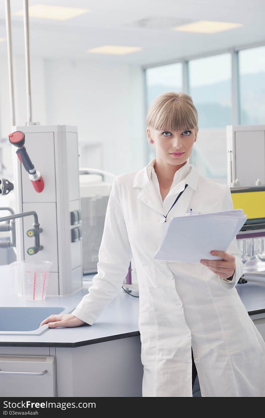 Doctor student female researcher holding up a test tube in chemistry bright labaratory. Doctor student female researcher holding up a test tube in chemistry bright labaratory