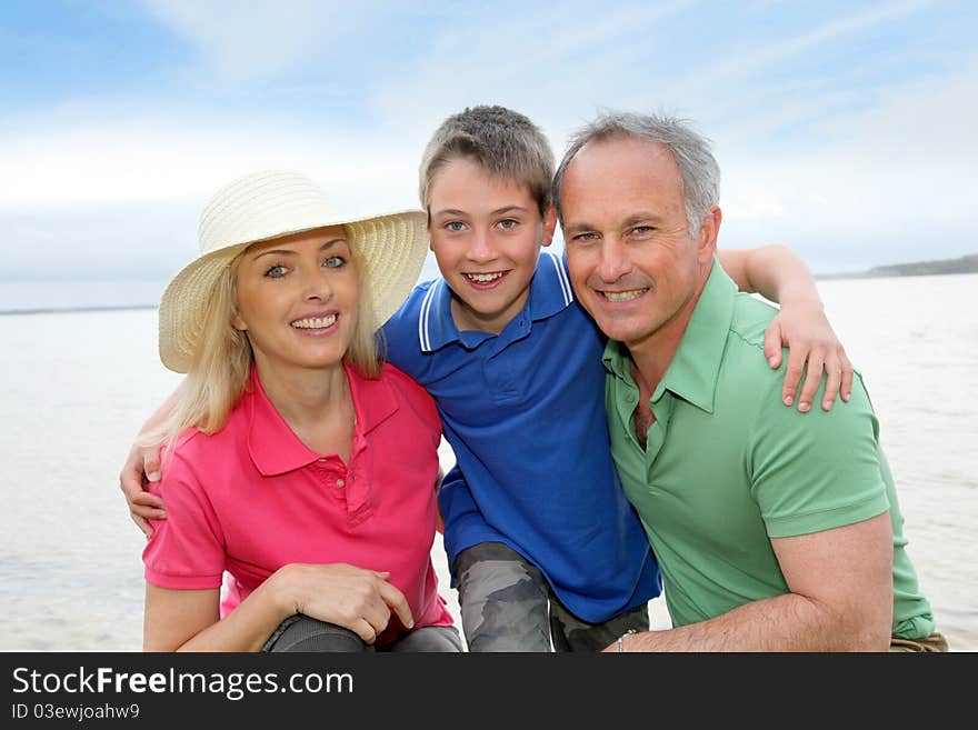 Portrait of happy family kneeling by a lake. Portrait of happy family kneeling by a lake