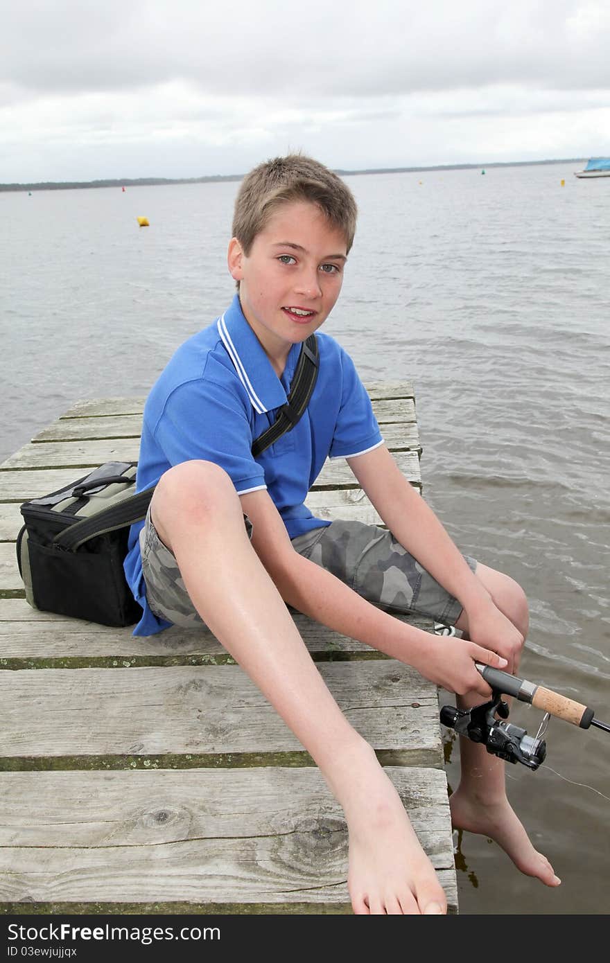 Kid sitting on a pontoon with fishing rod. Kid sitting on a pontoon with fishing rod