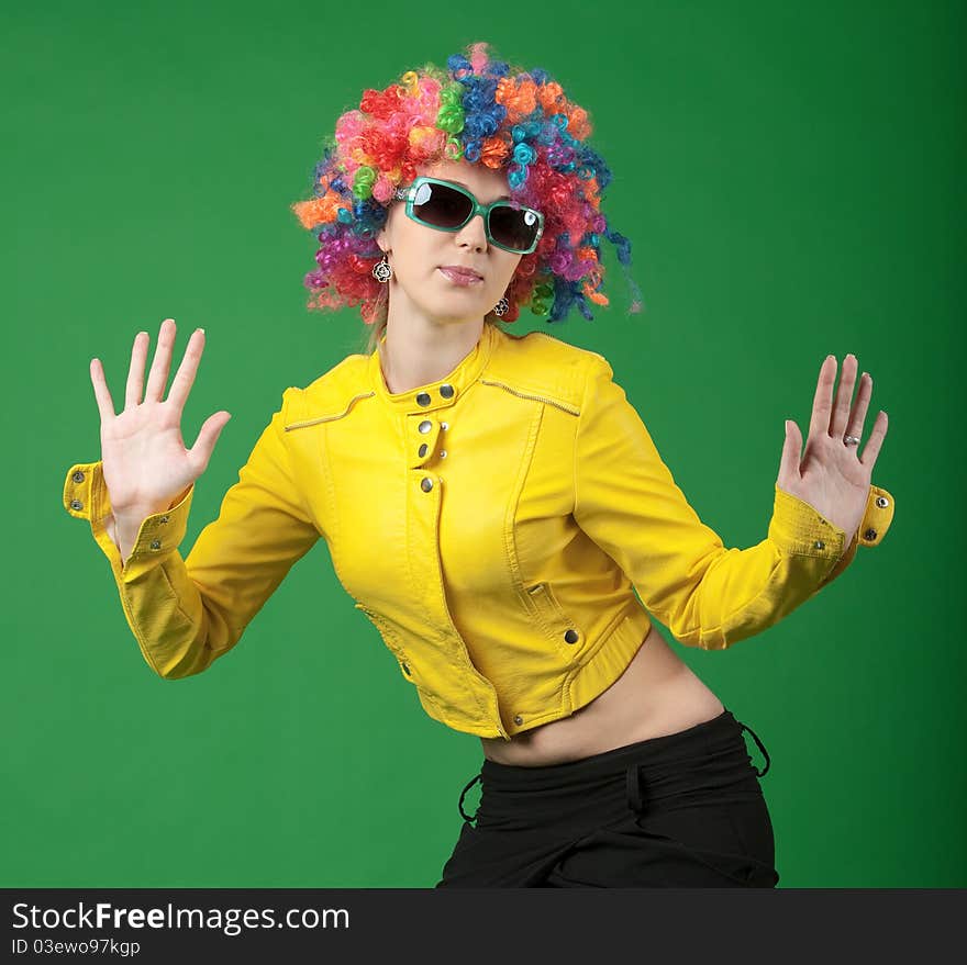 The girl in a color wig on green background. The girl in a color wig on green background