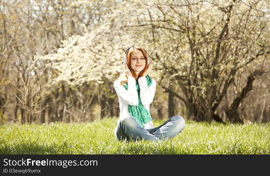 Redhead girl with headphone in the park