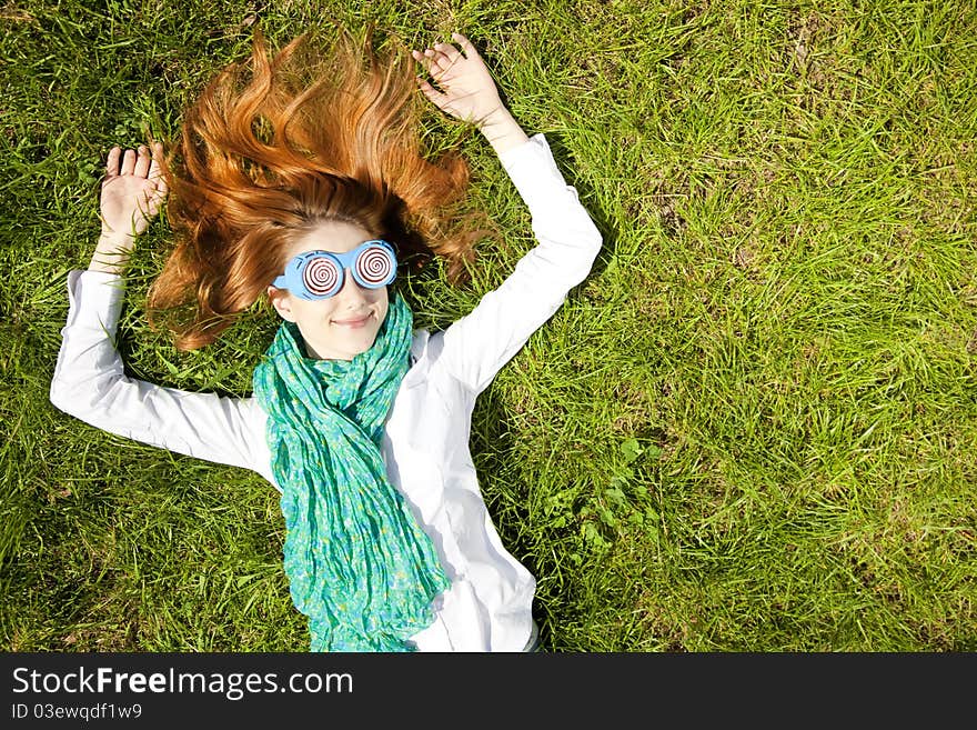 Girl lies at green grass in the park