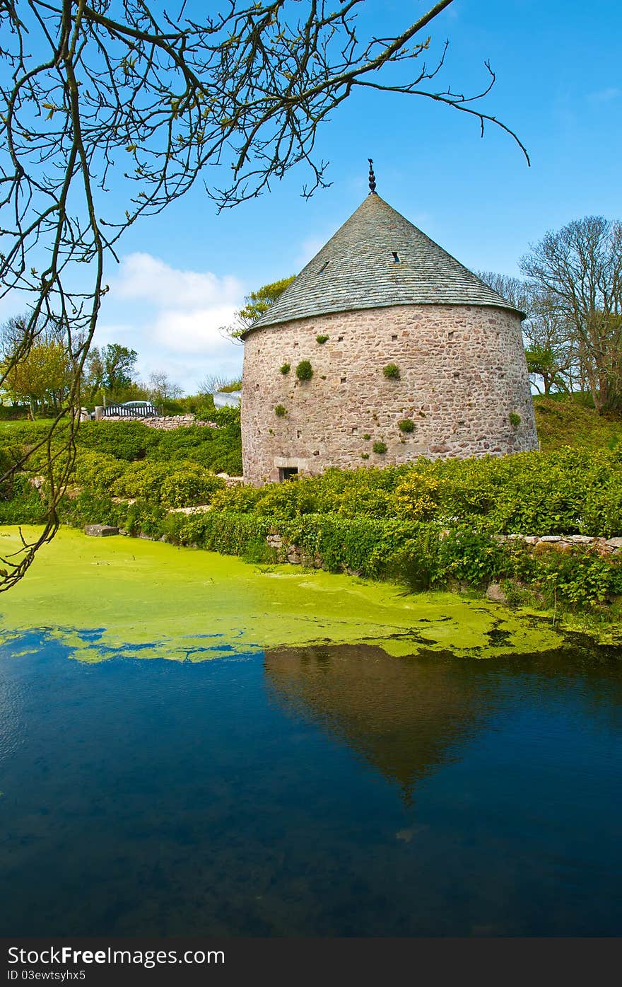 Small old house with a cylindrical roof with a pond infront, photographed in Northern France. Small old house with a cylindrical roof with a pond infront, photographed in Northern France.