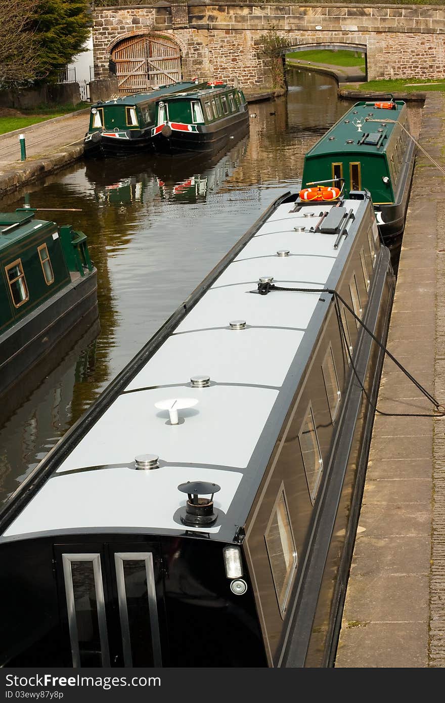 Five green narrow-boats moored up on the Llangollen canal. Five green narrow-boats moored up on the Llangollen canal