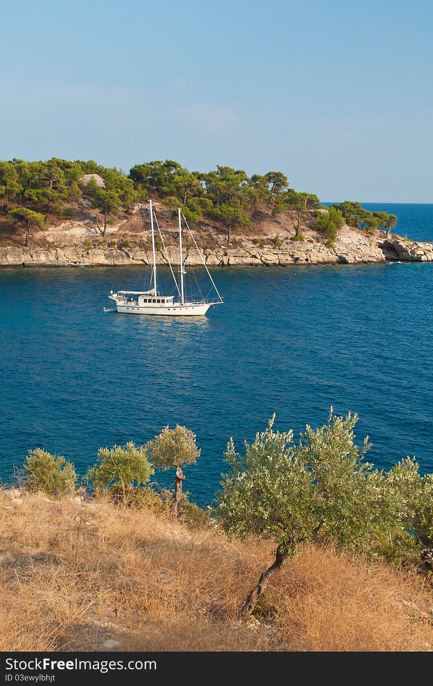 Whtie sailing boat, anchored in a gulf on the Mediteranian Sea in Greece. Whtie sailing boat, anchored in a gulf on the Mediteranian Sea in Greece.