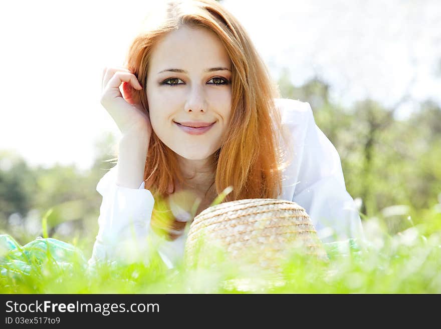 Red-haired girl with hat at the park.