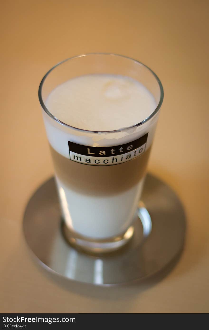 Latte macchiato on saucer on a table