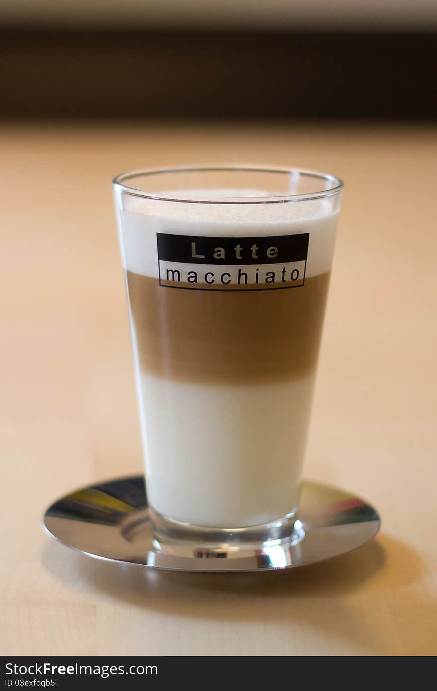 Latte macchiato on saucer on a table