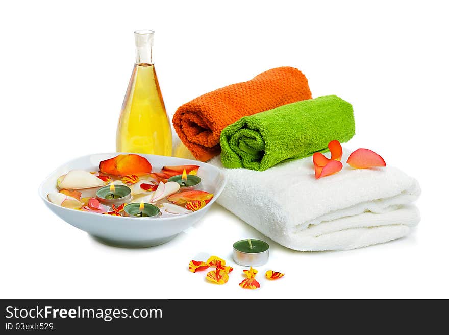 Bowl with rose petals, rose candle and towels on white background. Bowl with rose petals, rose candle and towels on white background