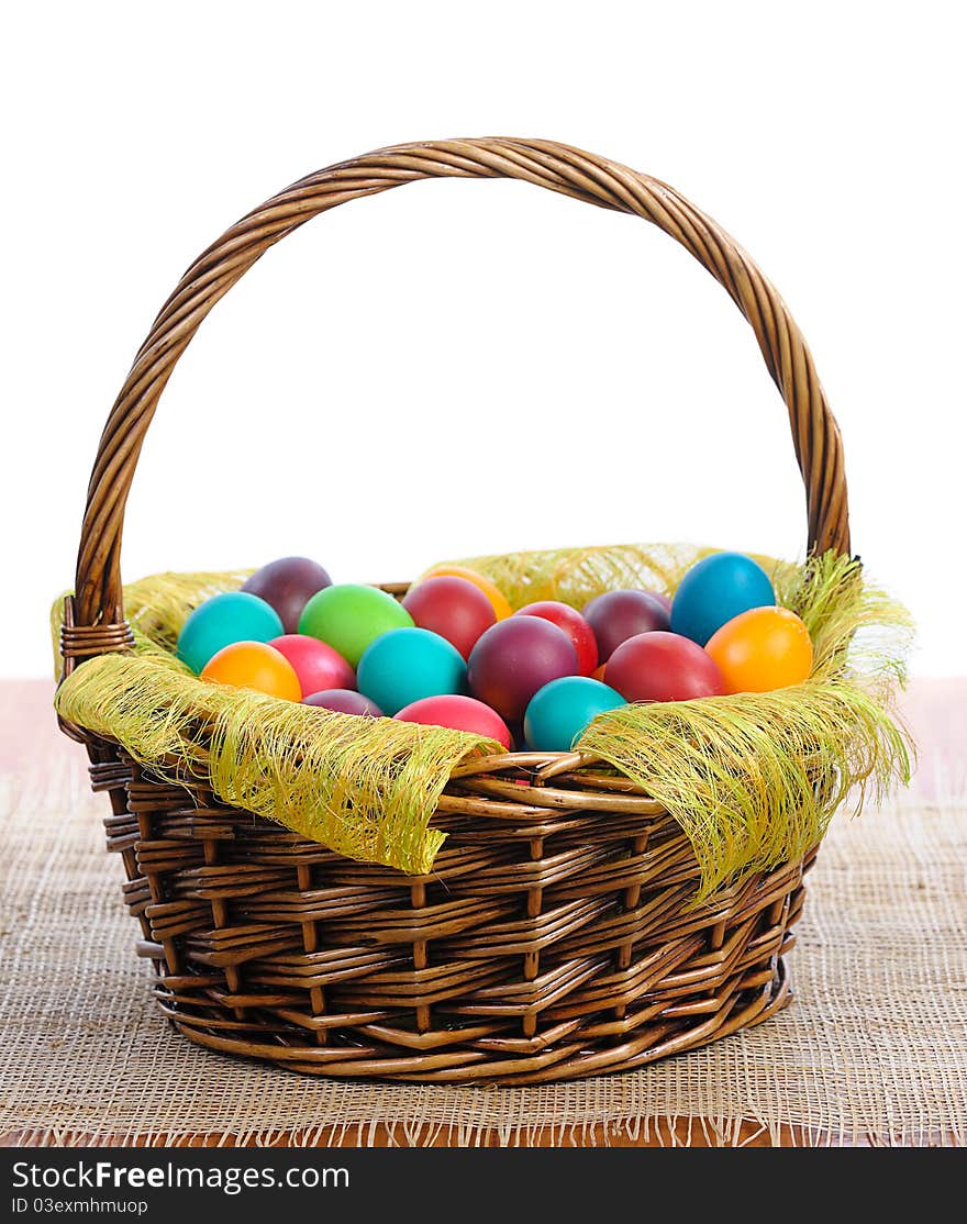 Colorful easter eggs in basket on white background