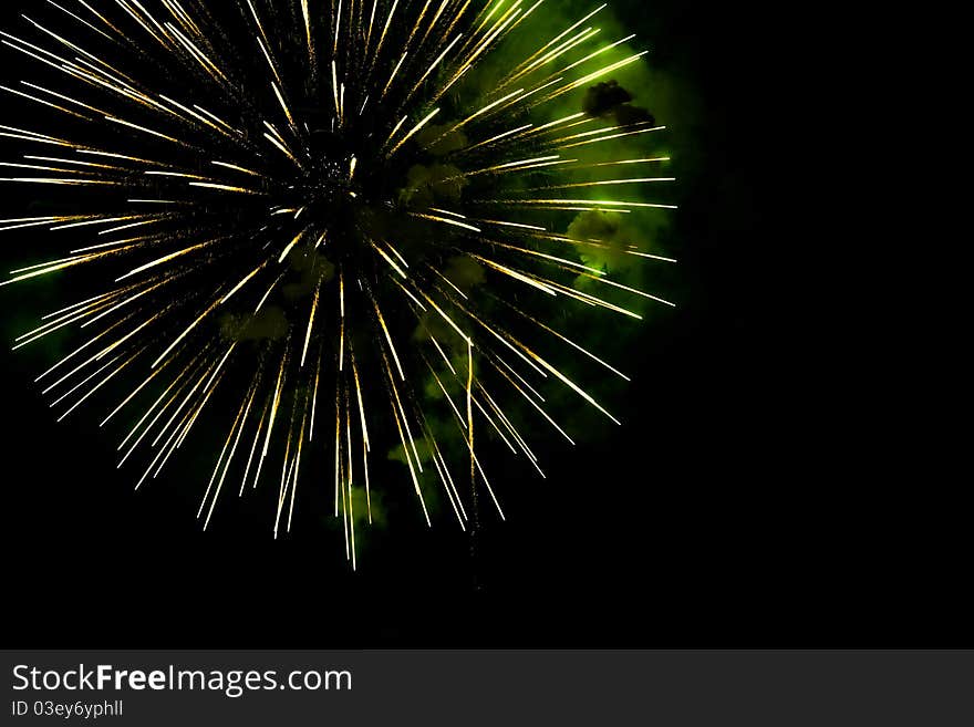 A burst of golden- green fireworks against a night sky. A burst of golden- green fireworks against a night sky.