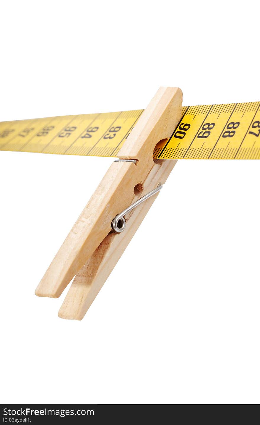 Clothespin and measuring tape isolated on a white surface. Clothespin and measuring tape isolated on a white surface.