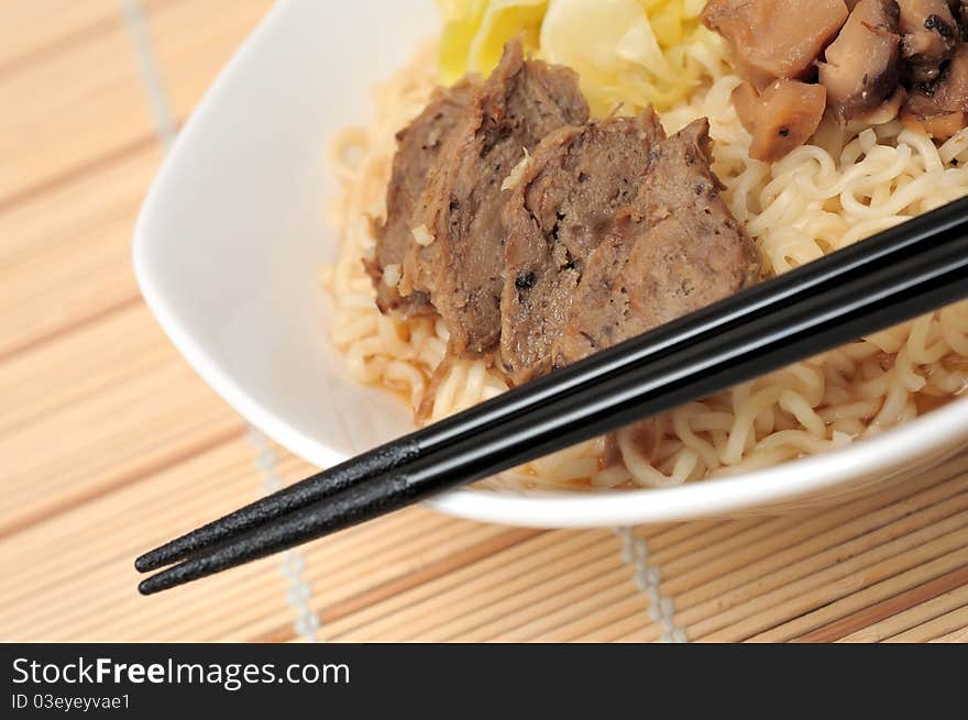 Asian style meat noodles in white bowl.