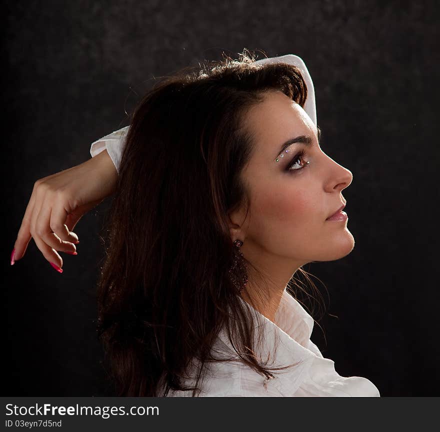 Portrait of an attractive woman in a white blouse on a black background