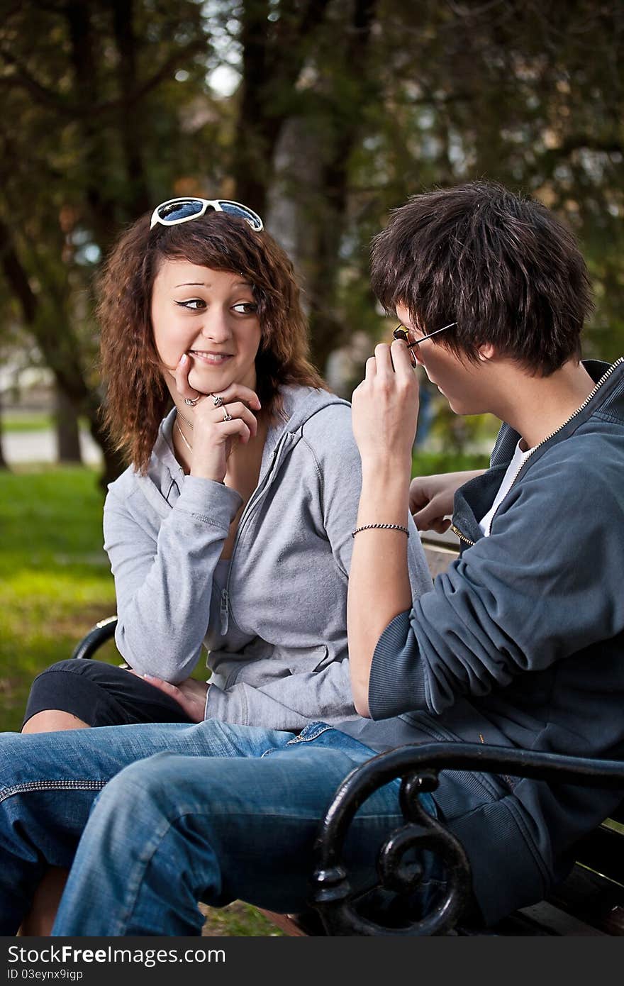 Attractive couple sitting on bench in the park