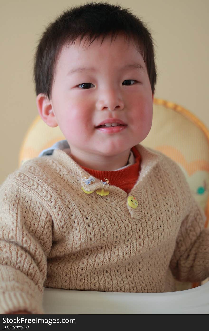 Cute and lovely chinese boy sitting on the baby chair. Cute and lovely chinese boy sitting on the baby chair