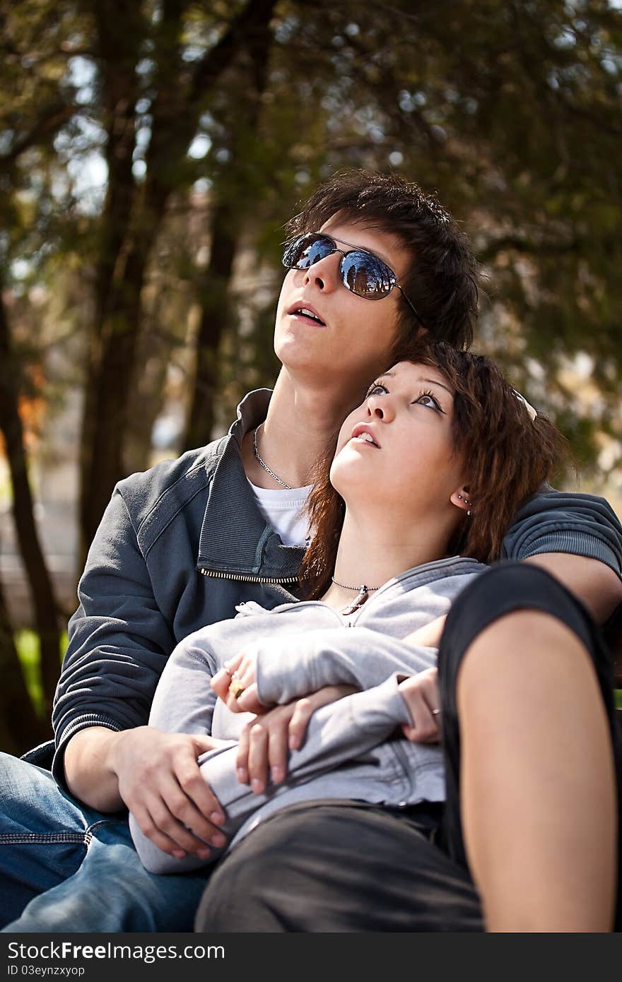 Attractive couple sitting on bench in the park