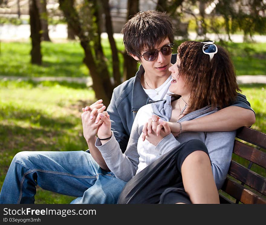 Attractive couple sitting on bench in the park