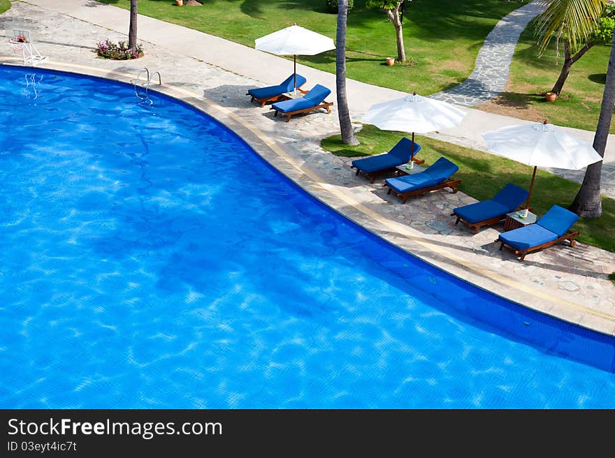 Chaise longue and umbrella at poolside. Chaise longue and umbrella at poolside