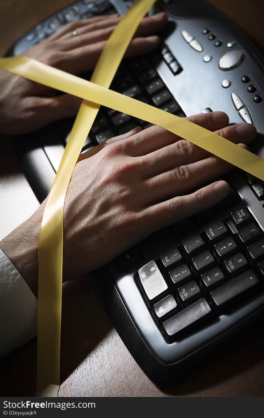 Close-up of a man's hand with duct tape typing at a computer keyboard. Close-up of a man's hand with duct tape typing at a computer keyboard