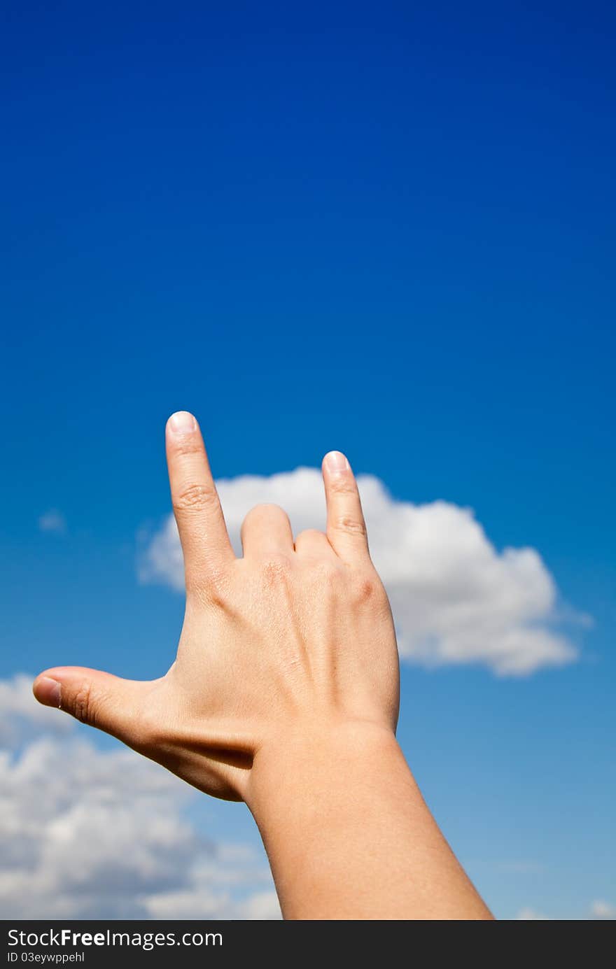 Hand Gesture - I love you against blue sky.