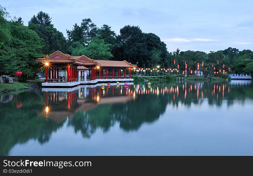 Chinese park at dusk lighted up with red lanterns.