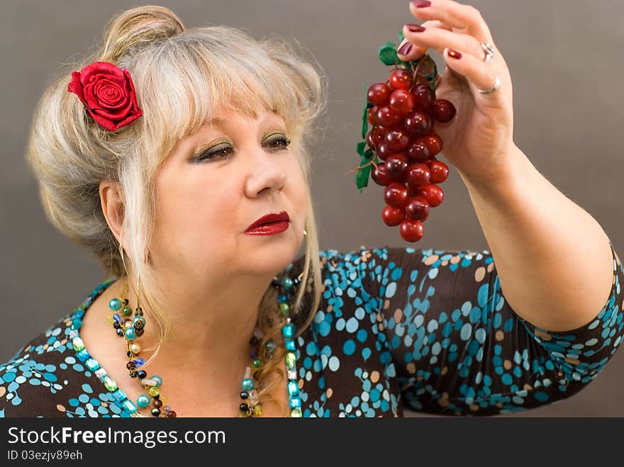 Portrait of a beautiful middle-aged women with red grape