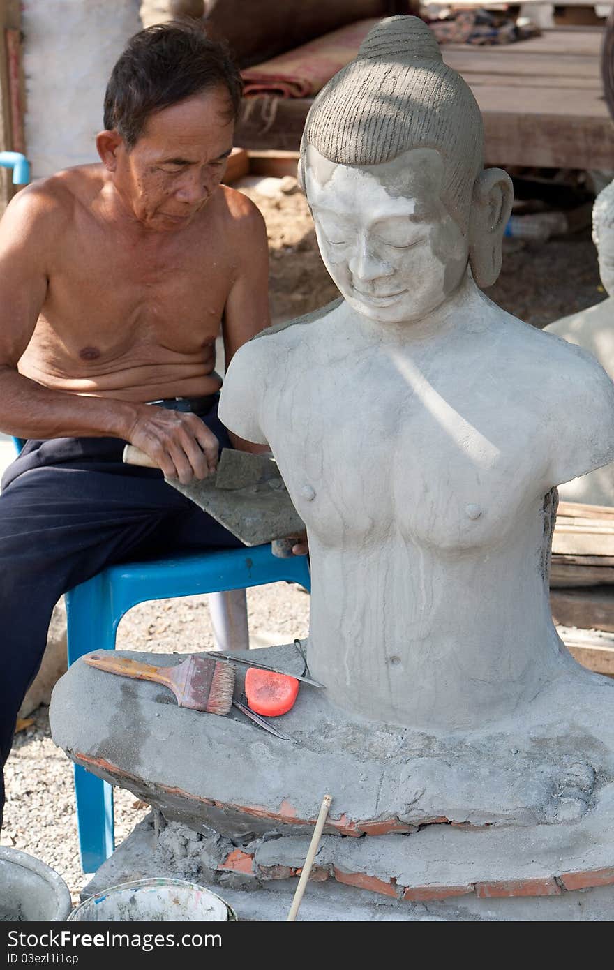 Restore buddhist figure, old Asian man with his craft