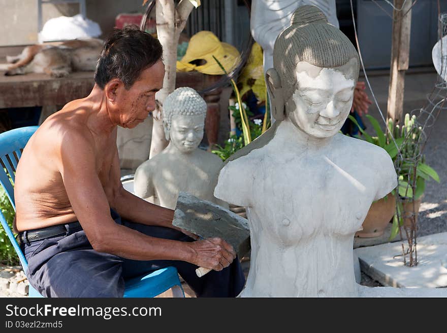 Restore buddhist figure, old Asian man with his craft