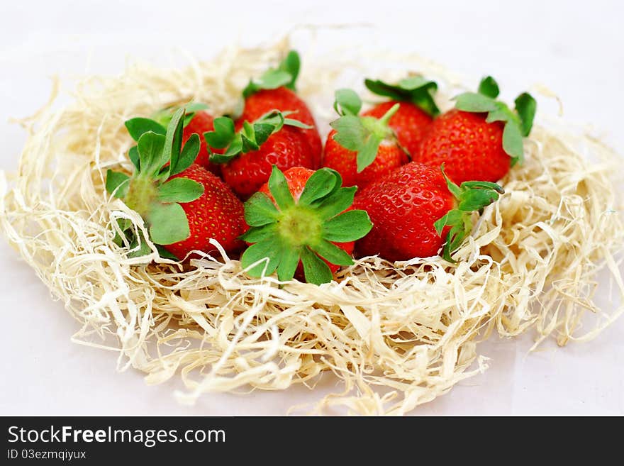 Strawberries in the hay on a white background