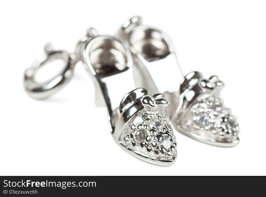 Macro view of little silver pendants in form of shoes. Macro view of little silver pendants in form of shoes