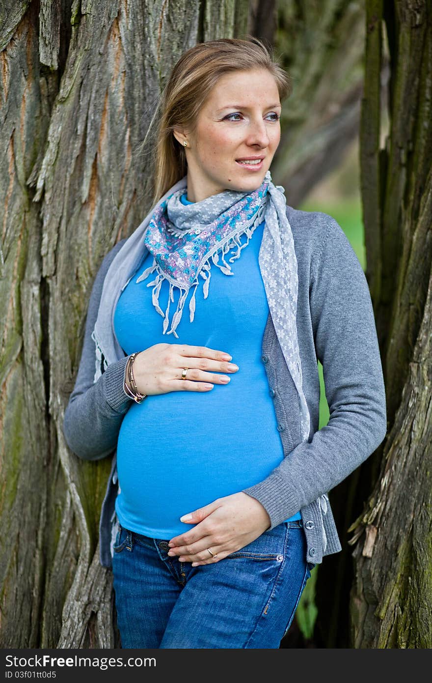 Pregnant woman outdoor in park at spring time