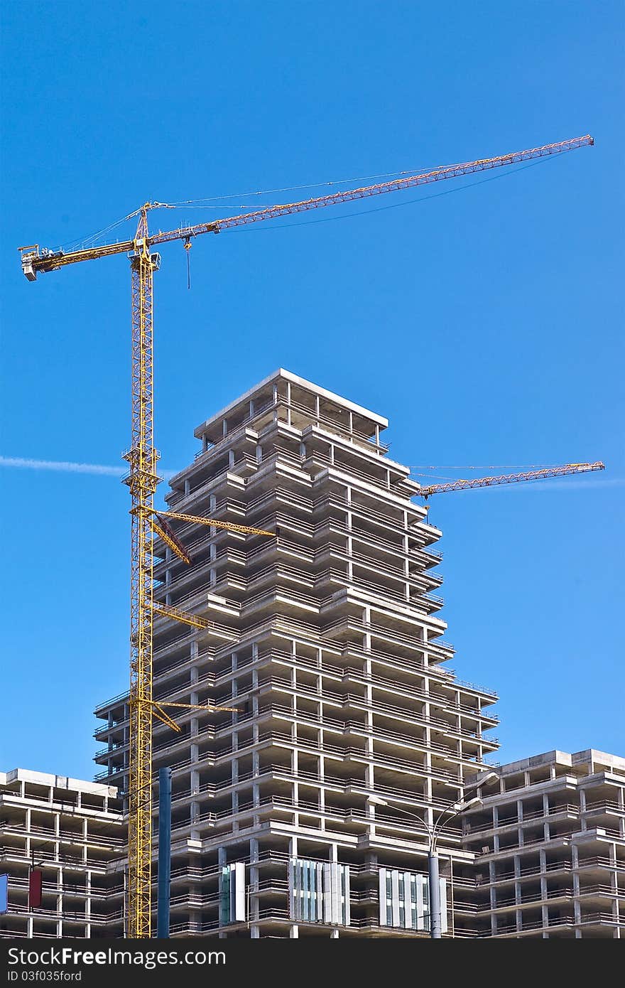 Modern high-rise building with two tower cranes. Modern high-rise building with two tower cranes