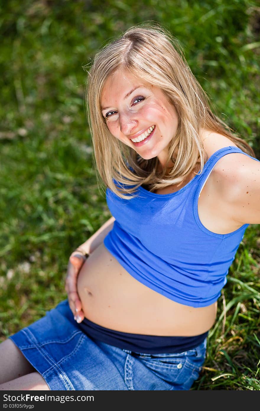 Pregnant woman outdoor in park at spring time