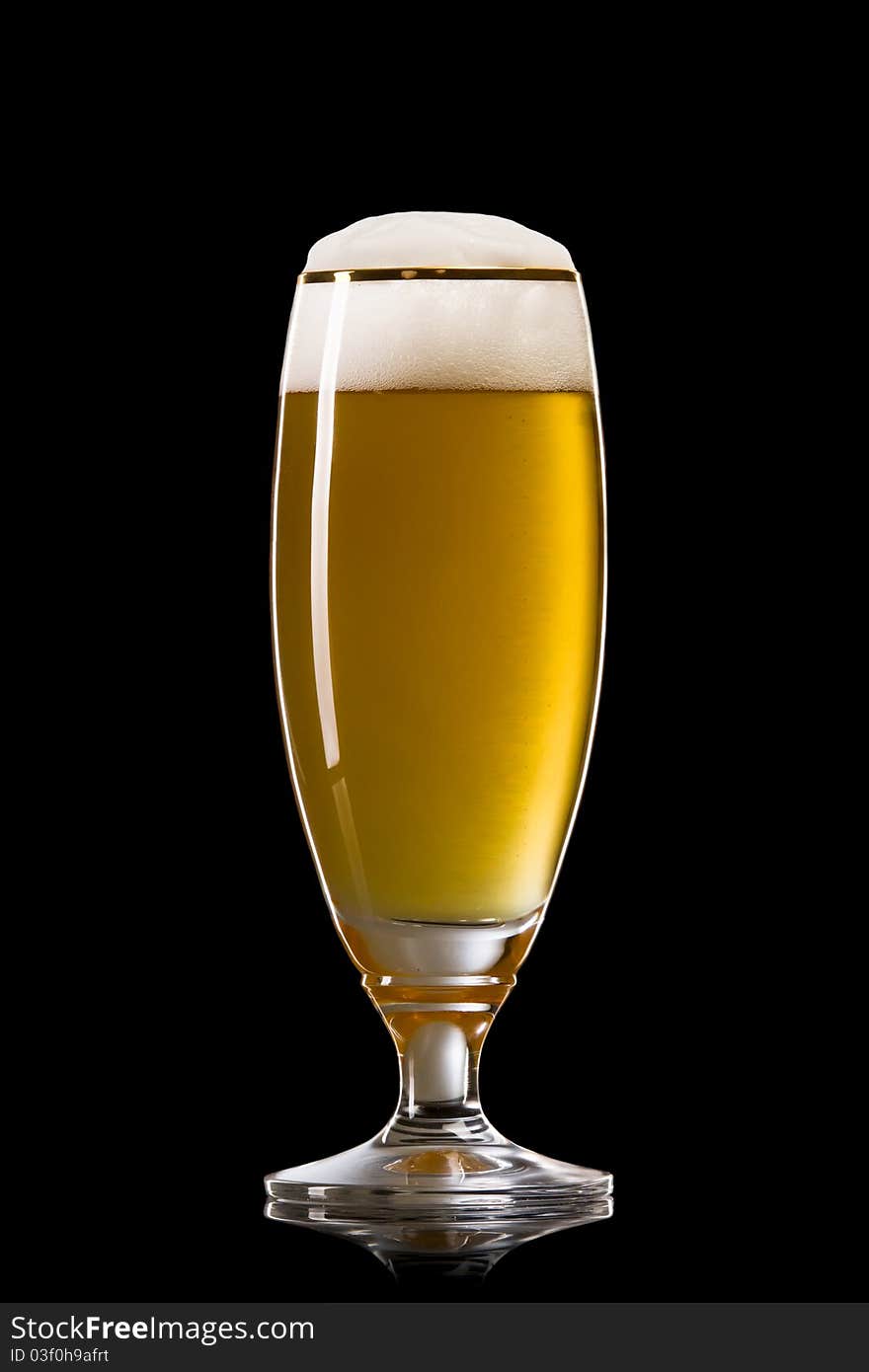 Beer into glass on a black background